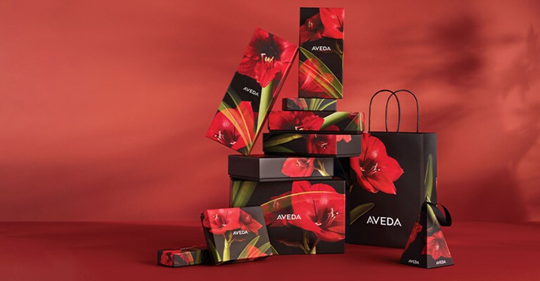Tower of aveda gift boxes that have a beautiful red flower on the boxes
