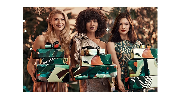 three women with wrapped holiday gifts