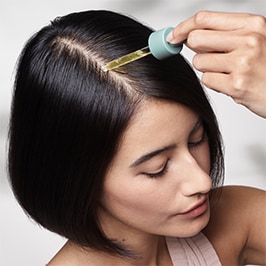 woman dropping product on scalp