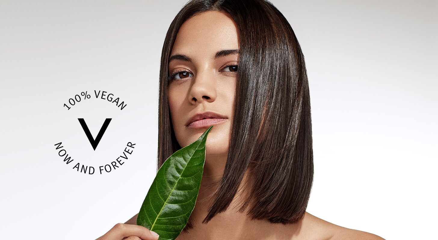 brunette woman with leaf and vegan seal on grey-silver background